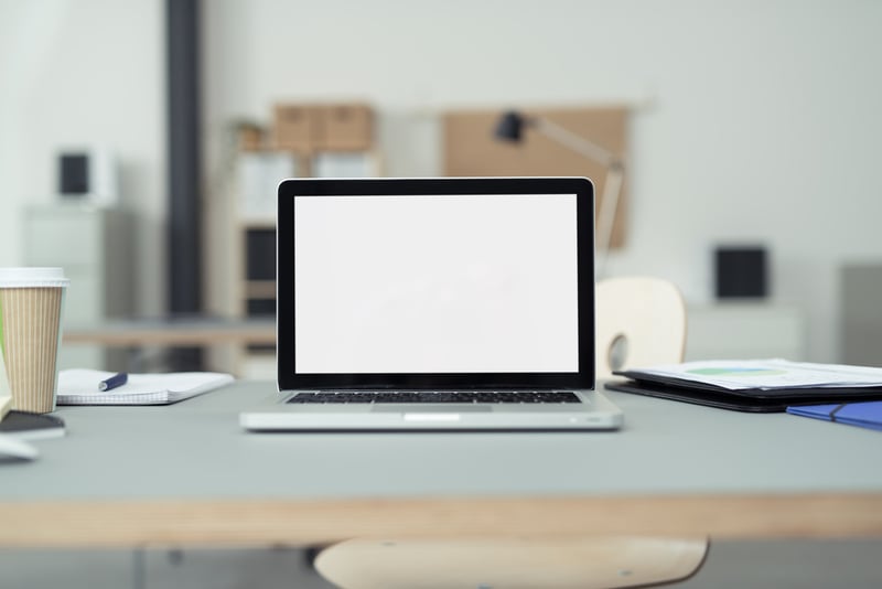 Close up Laptop Computer on Top of Office Table of a Businessman with Empty White Screen, Emphasizing Copy Space.